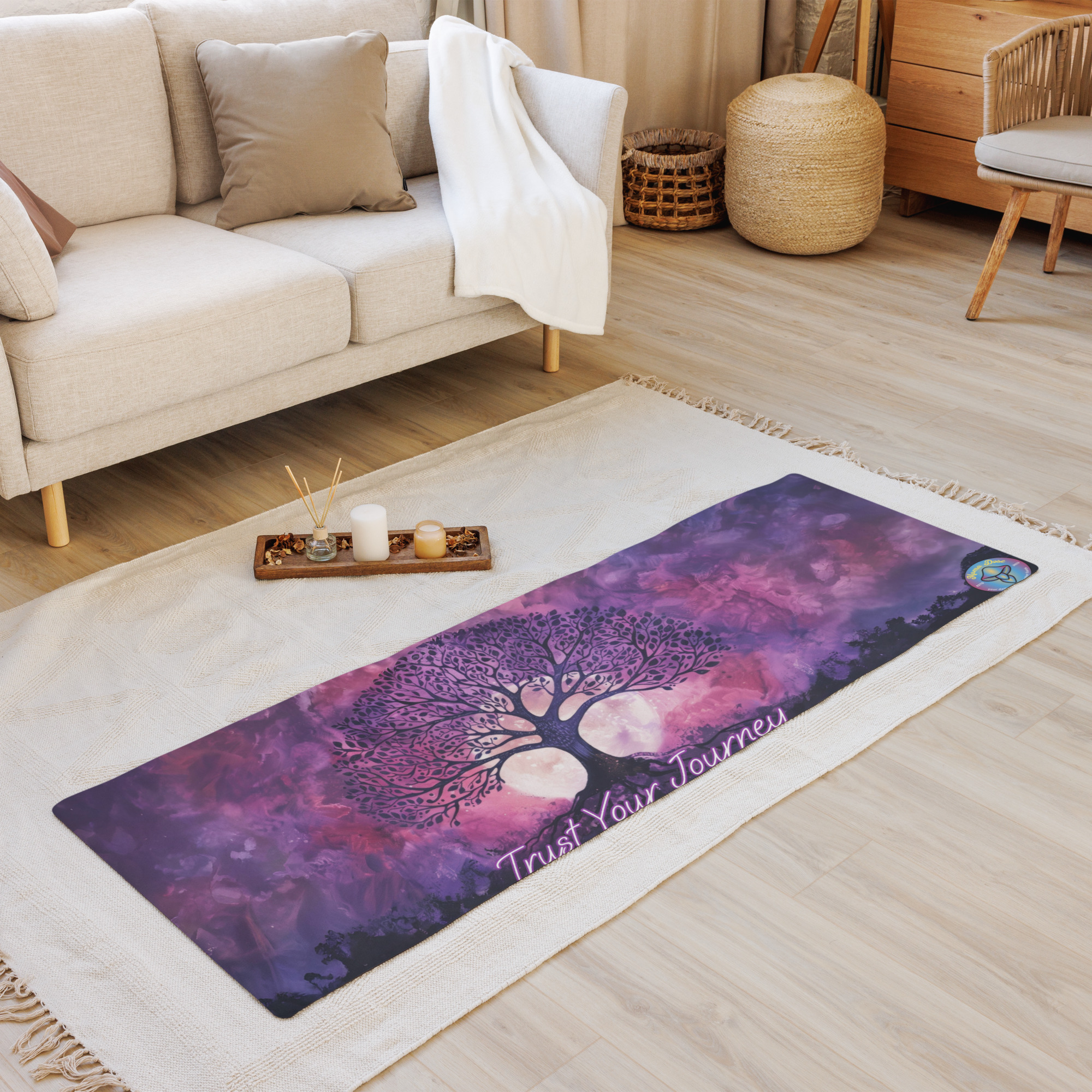 The Tree of Life Yoga Mat, featuring a purple tree design and "Trust Your Journey" text, is displayed on a beige rug in a cozy living room.