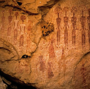 Ancient rock paintings depicting tall humanoid figures in ceremonial poses, an early record of humanity's engagement with mystical experience